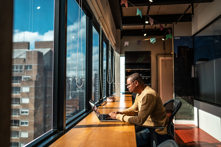 Mid adult man working using laptop at office