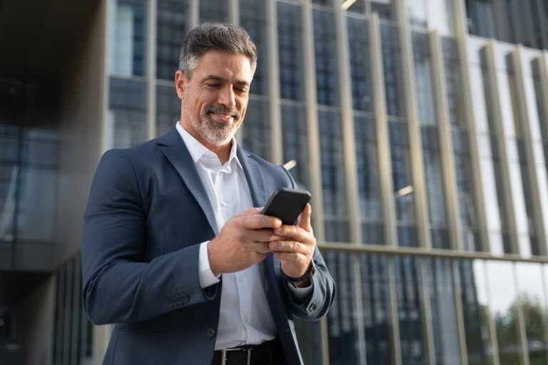 Successful businessman looking at his phone