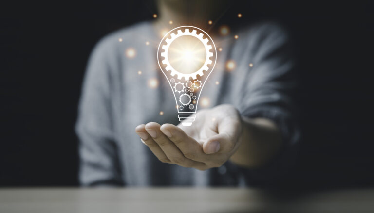 On the hand of a women with icon a light bulb And there is a gear icon on it. bright light bulb is idea innovation creativity inspiration brainstorming and imagination. technology education intellectual symbol future invention strategy energy light brain development science genius.