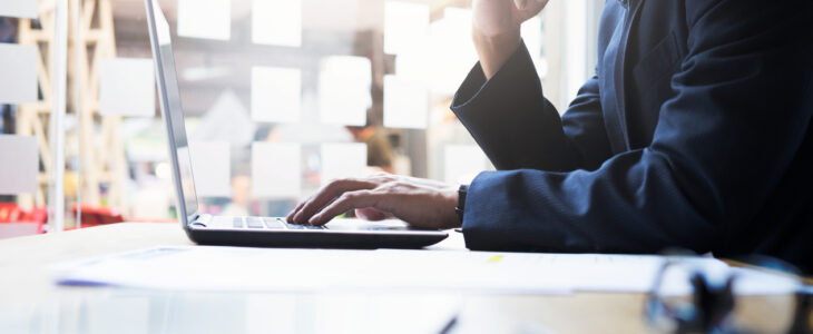 Startup businessman working analysis business information at office with laptop and documents on his desk.