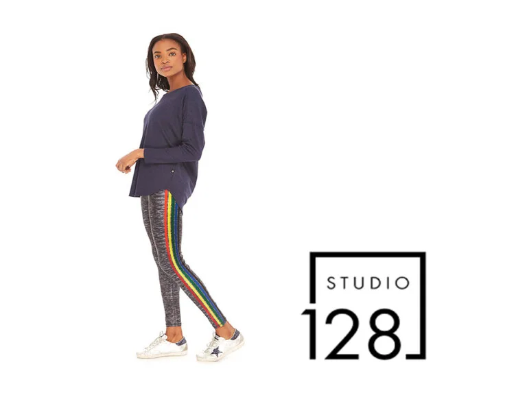 Woman in navy top and gray leggings with rainbow side stripes; Studio 128 logo.