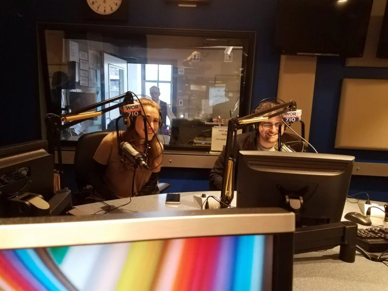 `Two radio hosts speaking into microphones in WOR 710 studio`