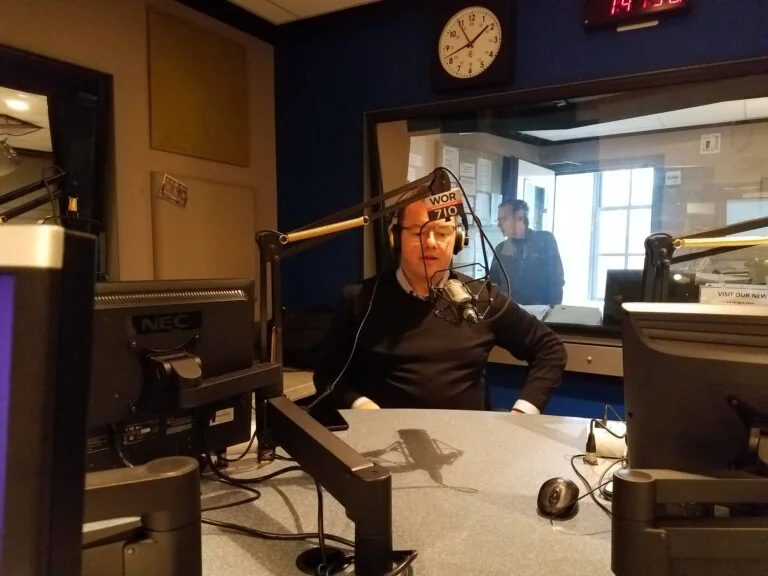 `Man speaking into microphone in WOR 710 radio studio`