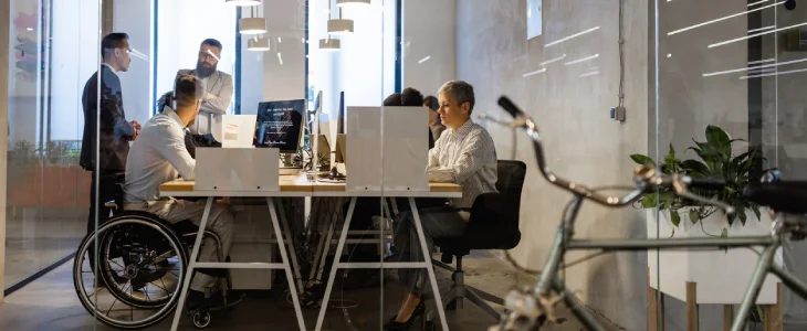 Group of people around a table with laptops