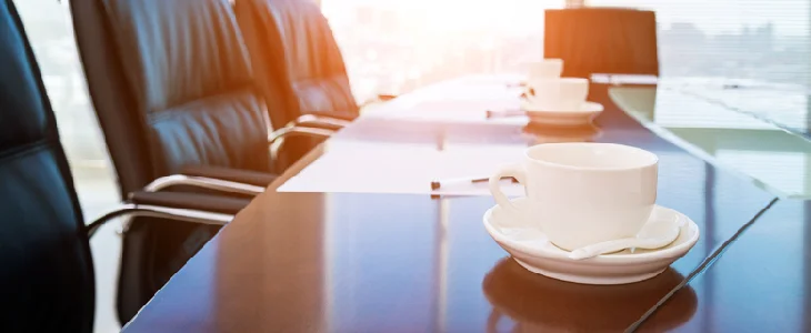 Empty meeting room with coffee cups on the desk