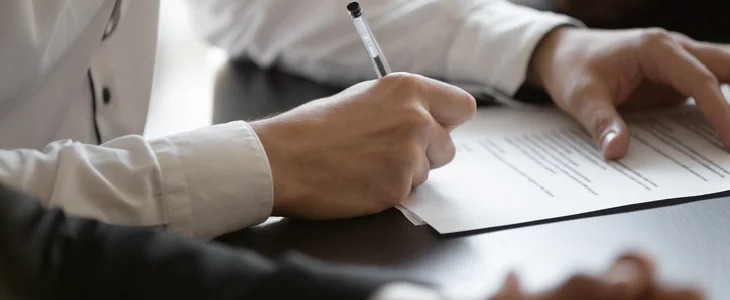 Man in a suit signing a paper