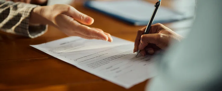person getting directed by another person to sign a document