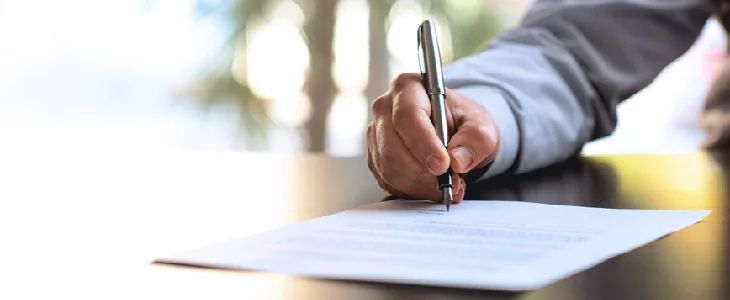 man writing on a piece of paper