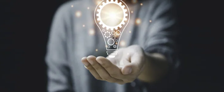 On the hand of a women with icon a light bulb And there is a gear icon on it. bright light bulb is idea innovation creativity inspiration brainstorming and imagination. technology education intellectual symbol future invention strategy energy light brain development science genius.